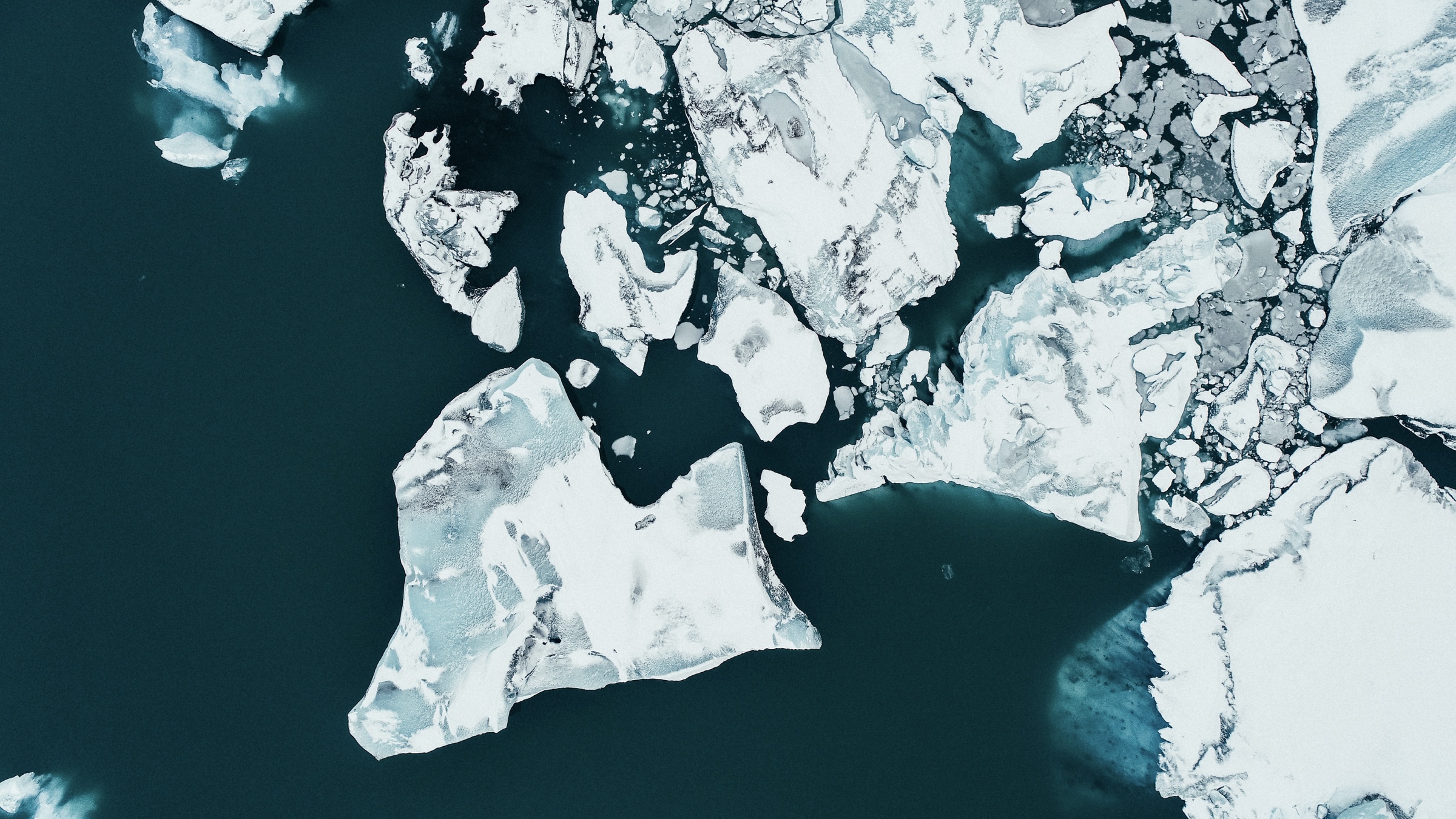 Aerial view of ice floes and glaciers in deep blue water